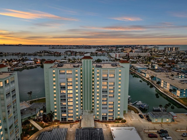 aerial view at dusk featuring a water view