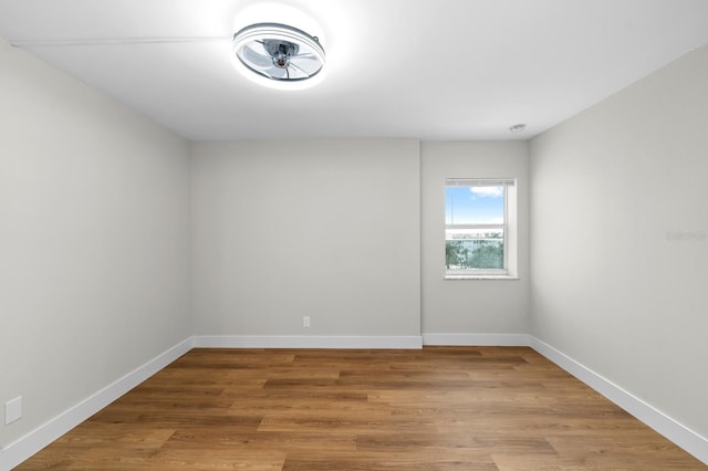 empty room featuring wood finished floors and baseboards