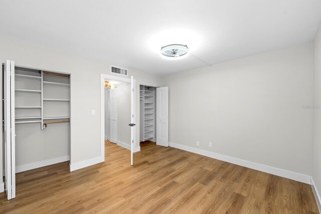 unfurnished bedroom featuring light wood-type flooring, visible vents, and baseboards