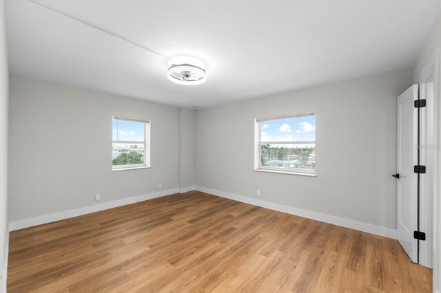 empty room with light wood-type flooring and baseboards