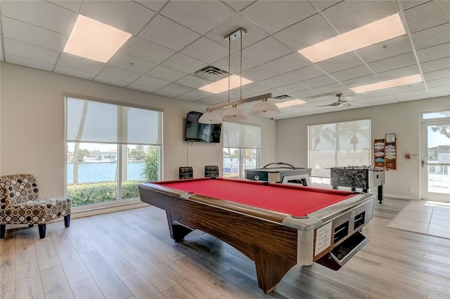 rec room with a healthy amount of sunlight, light wood-style flooring, visible vents, and a drop ceiling