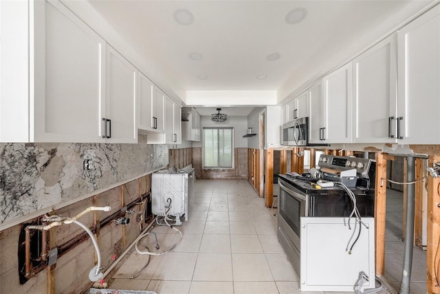 kitchen with light tile patterned floors, white cabinetry, and stainless steel appliances