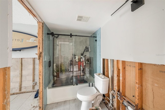 bathroom featuring toilet and shower / bath combination with glass door