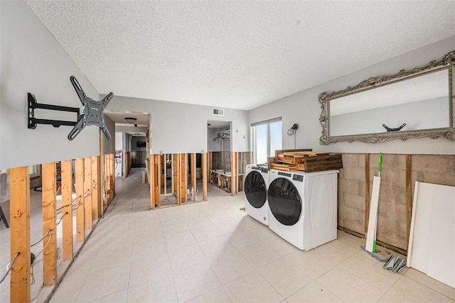 laundry room featuring washing machine and dryer and a textured ceiling