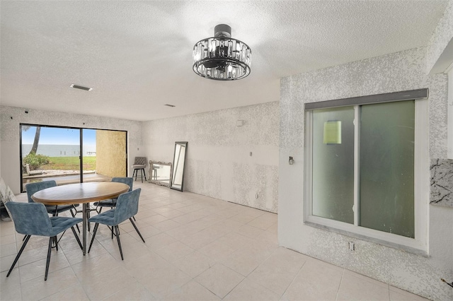 7300 Sunshine Skyway Ln S Unit 108, Saint Petersburg, FL 33711 - dining area with a textured ceiling, a chandelier, and light tile patterned floors