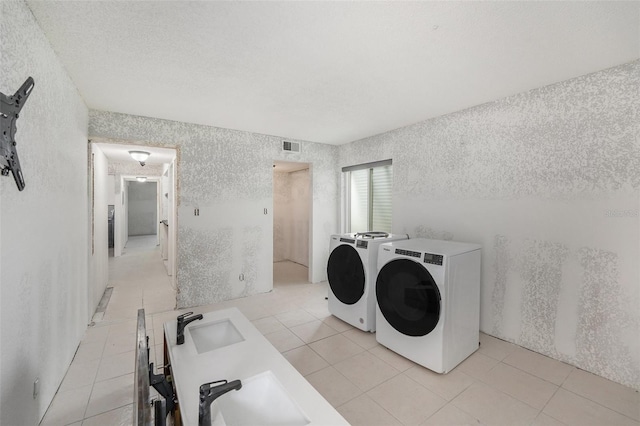 7300 Sunshine Skyway Ln S Unit 108, Saint Petersburg, FL 33711 - laundry room featuring washer and clothes dryer, light tile patterned floors, a textured wall, and a textured ceiling