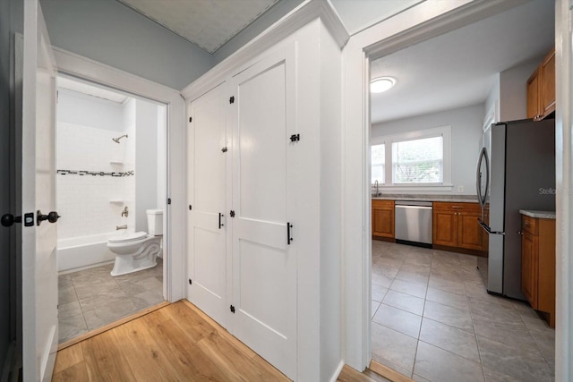 hall with light tile patterned floors and sink