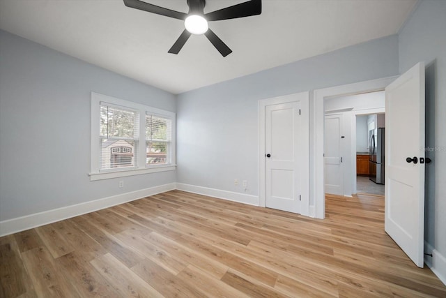 unfurnished bedroom with ceiling fan, light hardwood / wood-style flooring, and stainless steel refrigerator