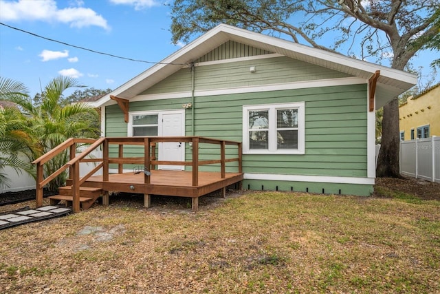 back of property featuring a lawn and a deck