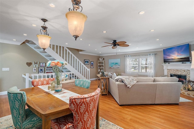 dining space with ceiling fan, ornamental molding, and light wood-type flooring