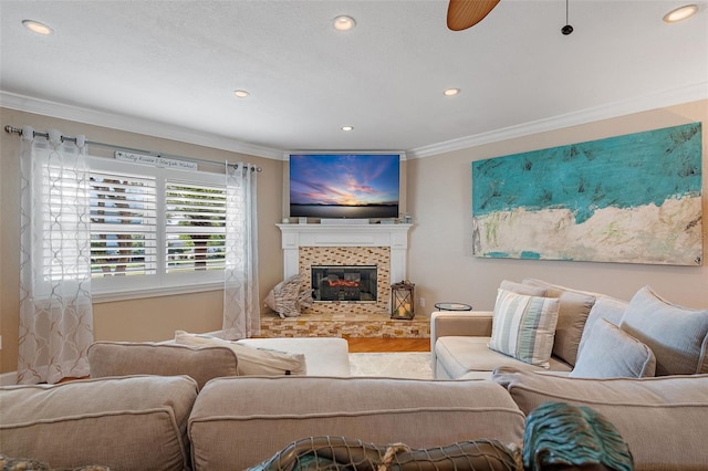 living room featuring ceiling fan, a fireplace, crown molding, and hardwood / wood-style floors