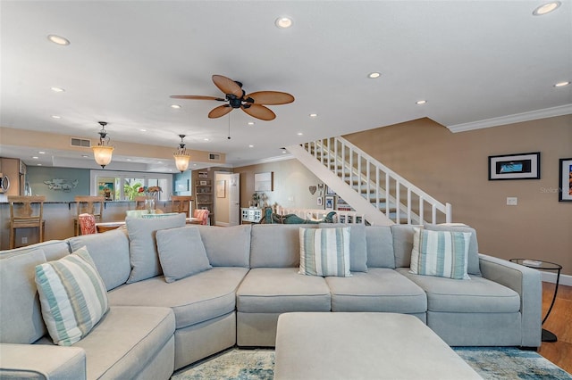 living room with ceiling fan, ornamental molding, and light hardwood / wood-style floors