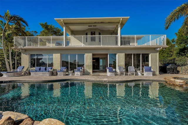 rear view of property featuring a balcony, an outdoor hangout area, and a patio