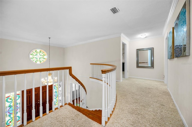 hallway featuring crown molding, a chandelier, and carpet flooring