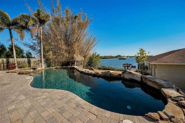 view of pool featuring a water view and a patio