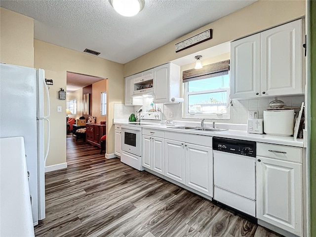 kitchen featuring white cabinetry, sink, dark hardwood / wood-style flooring, white appliances, and a textured ceiling