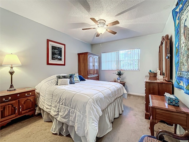 bedroom featuring ceiling fan, light colored carpet, and a textured ceiling