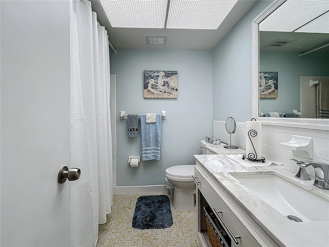 bathroom featuring tasteful backsplash, vanity, and toilet