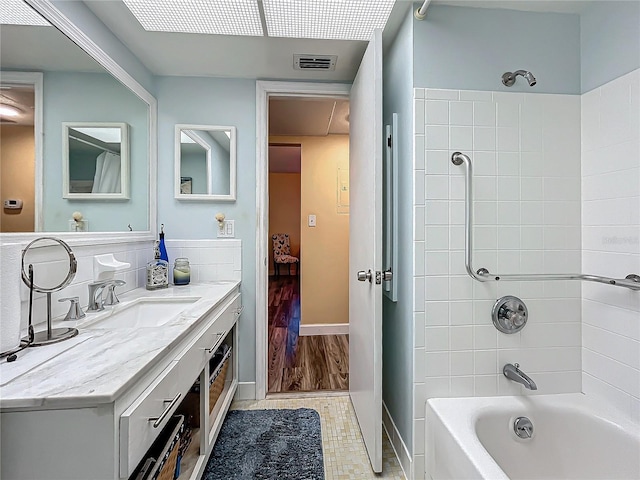 bathroom with vanity and tiled shower / bath combo