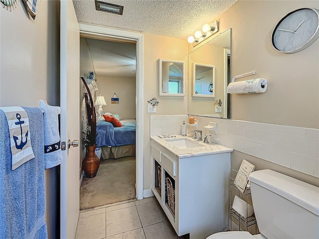 bathroom with vanity, tile patterned floors, a textured ceiling, and toilet