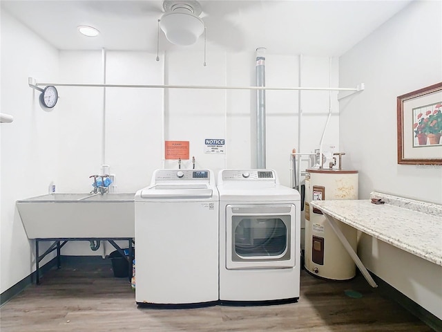 laundry room featuring sink, washer / dryer, light hardwood / wood-style flooring, and electric water heater