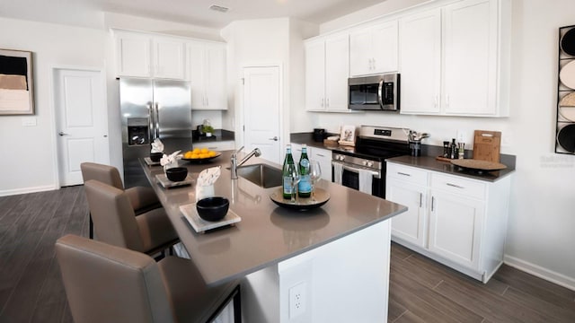 kitchen featuring an island with sink, white cabinets, appliances with stainless steel finishes, and sink