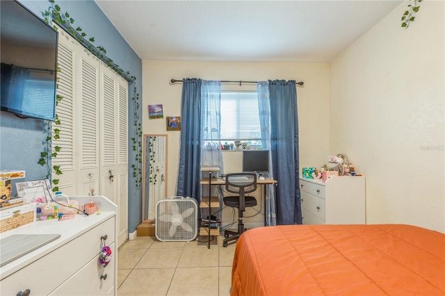 bedroom with light tile patterned floors and a closet