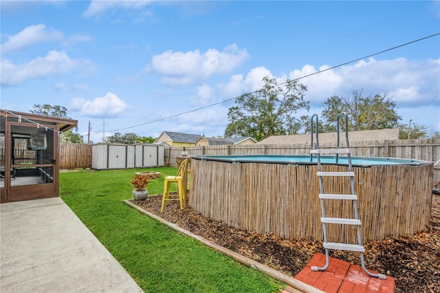 view of yard featuring a fenced in pool and a storage unit