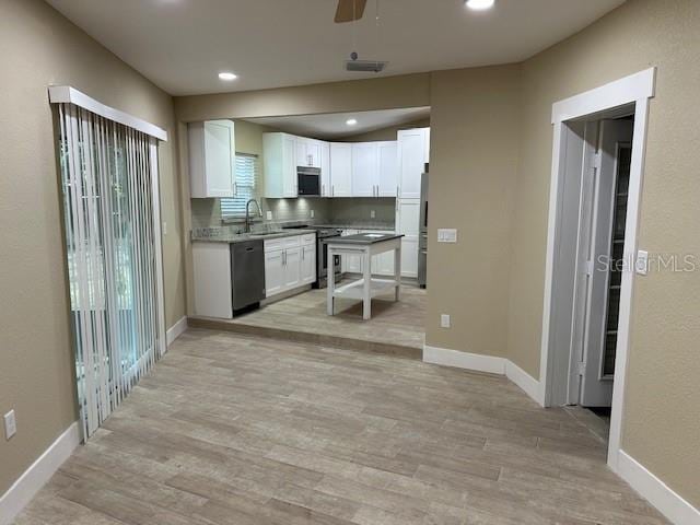 kitchen featuring light hardwood / wood-style floors, white cabinetry, stainless steel appliances, and ceiling fan