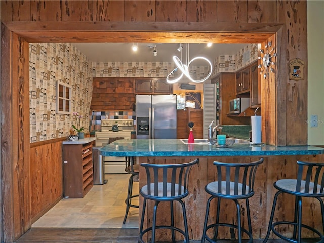 kitchen featuring appliances with stainless steel finishes, sink, a kitchen breakfast bar, and kitchen peninsula