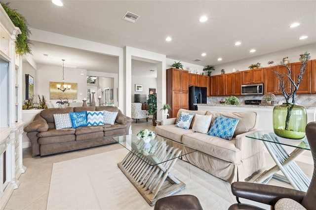 living room with light tile patterned floors and a notable chandelier