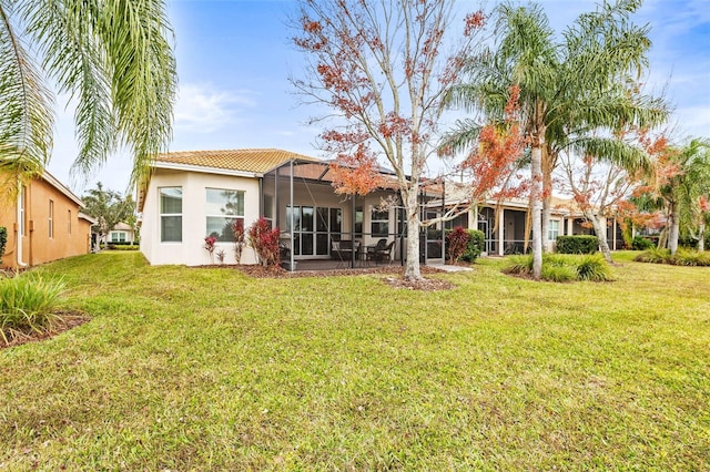 rear view of property featuring a lanai and a yard