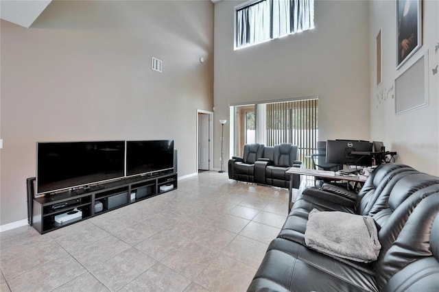 living room featuring light tile patterned floors and a towering ceiling