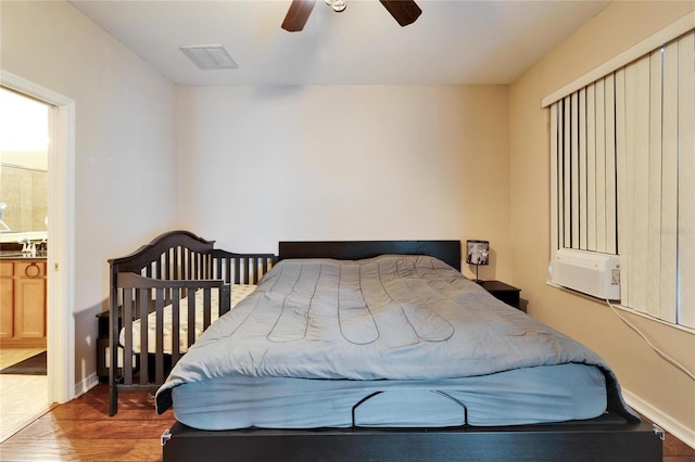 bedroom with ceiling fan, wood-type flooring, and ensuite bathroom