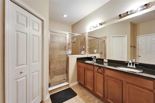 bathroom featuring tile patterned floors, vanity, and an enclosed shower