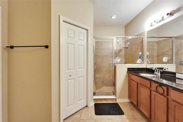 bathroom with an enclosed shower, vanity, and tile patterned flooring