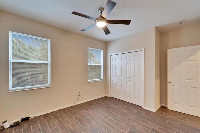 unfurnished bedroom with ceiling fan and a closet