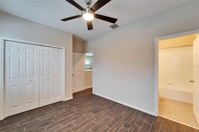 unfurnished bedroom with ceiling fan, a closet, and connected bathroom