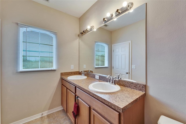 bathroom featuring toilet, a wealth of natural light, tile patterned floors, and vanity