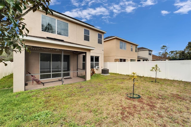 rear view of house featuring central air condition unit, a yard, and a patio