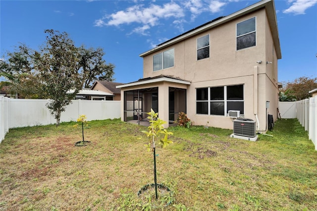 back of house with a sunroom, a yard, and central AC unit