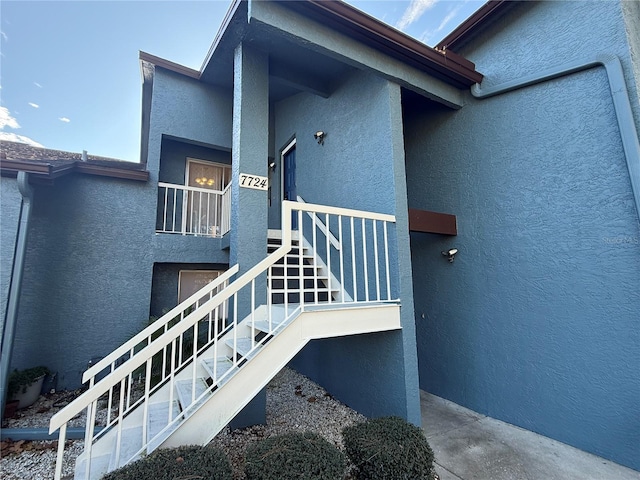 doorway to property featuring stucco siding