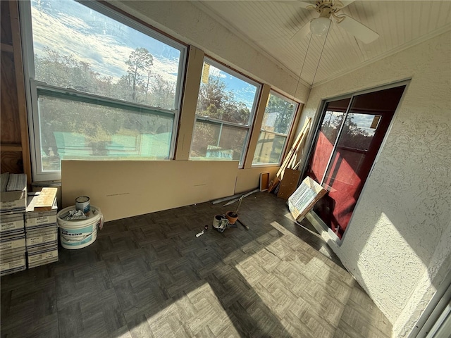 unfurnished sunroom featuring ceiling fan