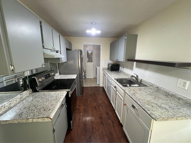 kitchen with appliances with stainless steel finishes, sink, decorative backsplash, dark wood-type flooring, and a textured ceiling