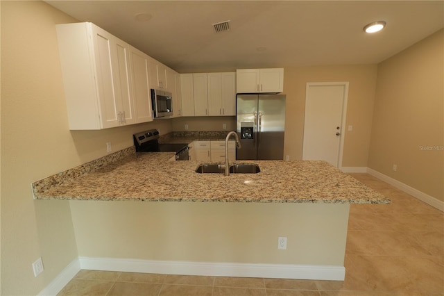 kitchen featuring white cabinetry, kitchen peninsula, appliances with stainless steel finishes, light stone countertops, and sink