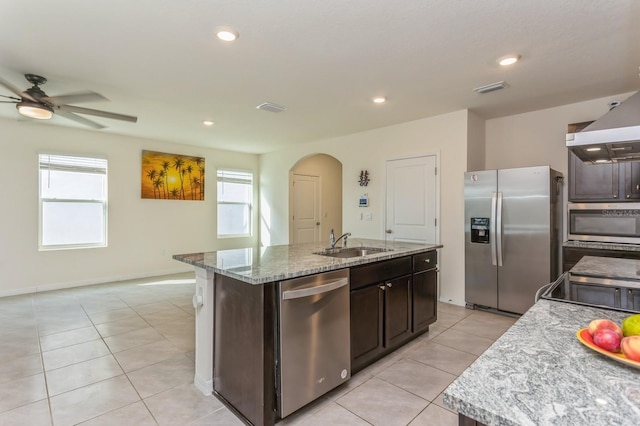 kitchen featuring sink, light tile patterned floors, ceiling fan, stainless steel appliances, and an island with sink