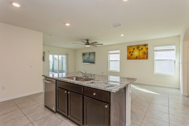 kitchen with dark brown cabinetry, sink, dishwasher, ceiling fan, and a kitchen island with sink