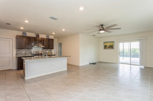 kitchen with dark brown cabinets, a kitchen island with sink, electric range, and ceiling fan