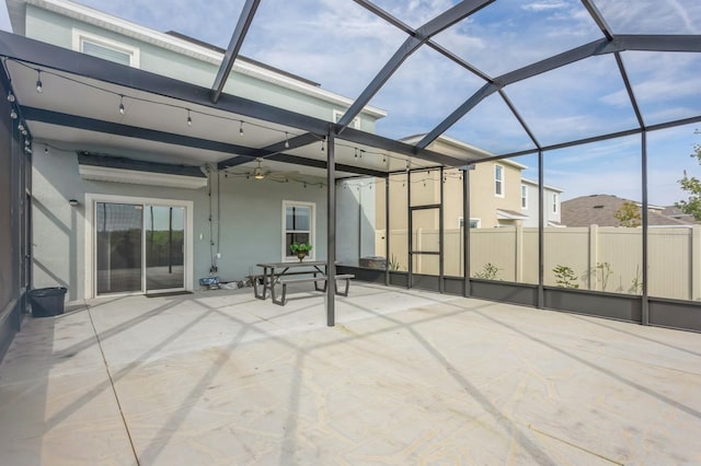 view of patio / terrace featuring ceiling fan and glass enclosure