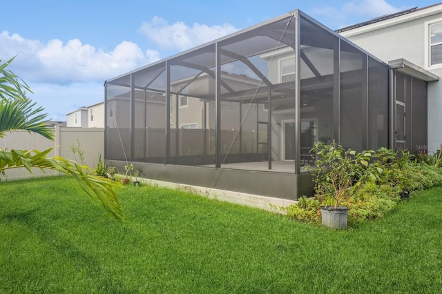 rear view of property featuring a lanai and a lawn